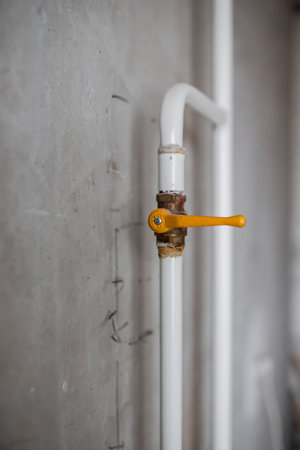 Gas communications in the house - white metal pipes with a yellow ceiling tap - sealed gas meterの写真素材