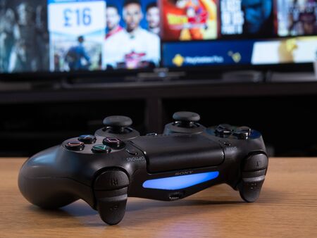 UK, Jan 2020: Sony dualshock remote controller wireless for Playstation 4 in front of online store...