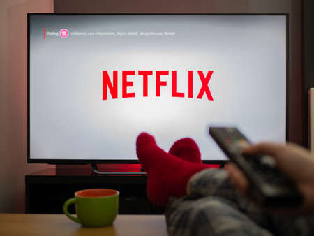 UK, March 2020: TV Television Netflix logo watching with feet up comfy at homeのeditorial素材