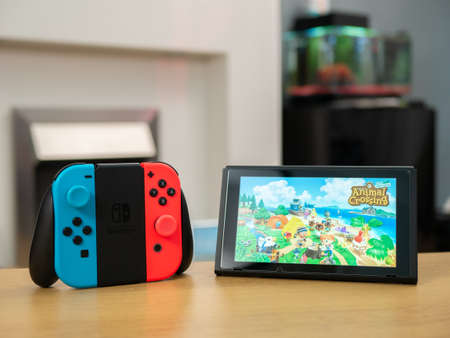 UK, March 2020: Nintendo Switch animal crossing new horizons and joy con grip in home settingのeditorial素材