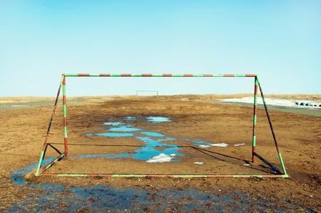 Football goal on the field with puddlesの写真素材