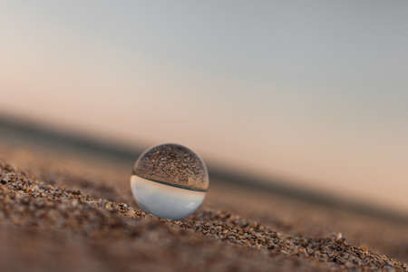 glass optical ball on the sandy azure coast of the seaの写真素材