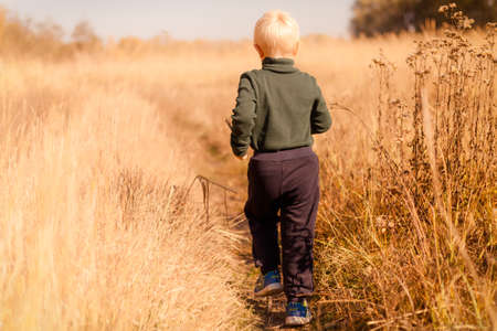 A man standing on a dry grass fieldの写真素材