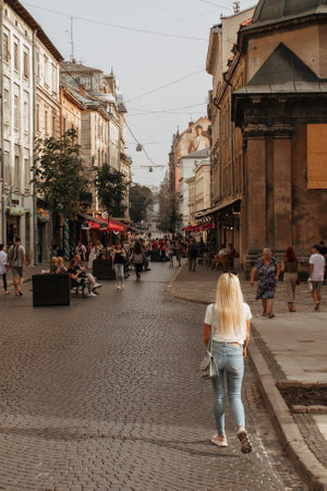 young woman with disposable cup drinking coffee lviv opera building a