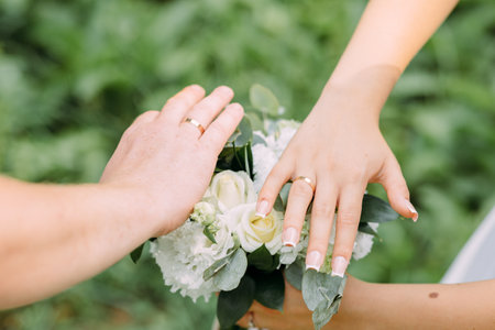 The bride and groom show wedding rings, the hands of two loversの写真素材