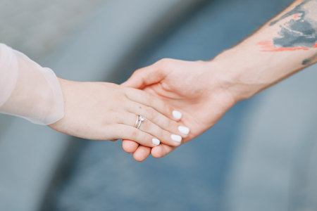 The bride and groom show wedding rings, the hands of two loversの写真素材