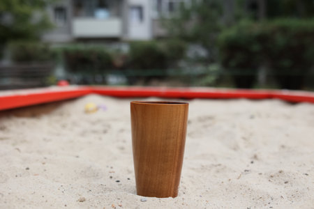 Handmade wood water glass or wooden cup on white sand.の写真素材