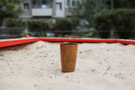 Handmade wood water glass or wooden cup on white sand.の写真素材