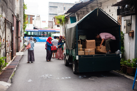 A working man unloads boxes from a lorryのeditorial素材