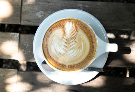 Top view of hot latte coffee on classic wood tableの写真素材