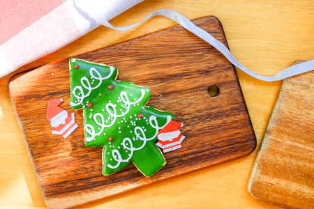 Christmas tree cookie and paper Santa on wooden plate. Christmas theme tableの写真素材