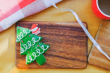 Christmas tree cookie and paper Santa on wooden plate. Christmas theme tableの写真素材