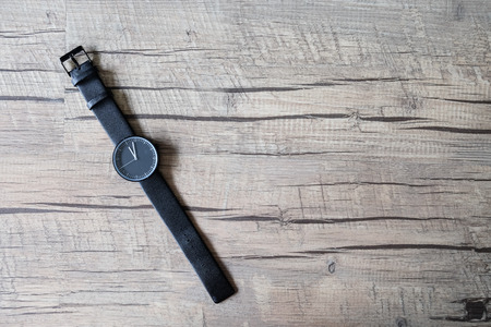 Minimal black watch on artificial wood backgroundの写真素材