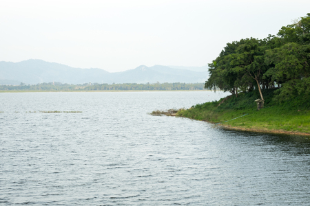 Peaceful lake and shore in cloudy dayの写真素材