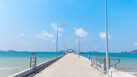 Walkway to pier among blue sea and clear skyの写真素材