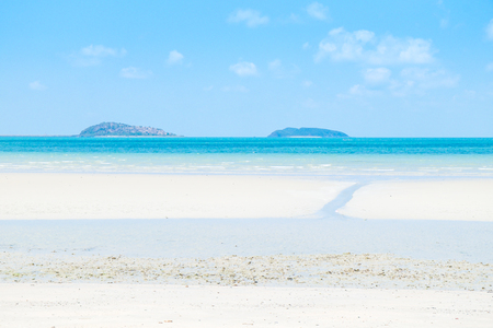 Calm white sand beach under blue skyの写真素材