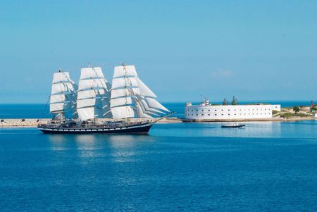 Sailing ship entering to the bay.
