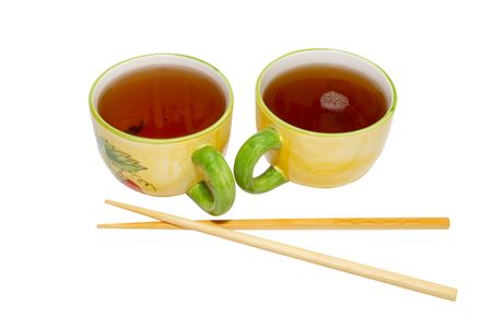Two teacups with tea and chopsticks isolated on white.の写真素材