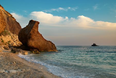 Tropical beach on the sunset with water and rocks.の写真素材