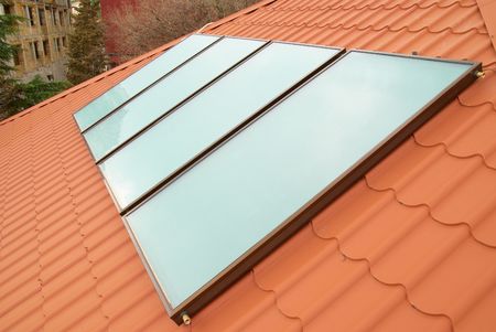 Solar water heating system (geliosystem) on the red house roof.の写真素材