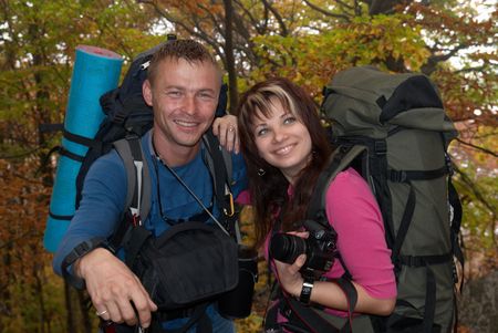 Young tourist couple in the autumn park with rucksacksの写真素材