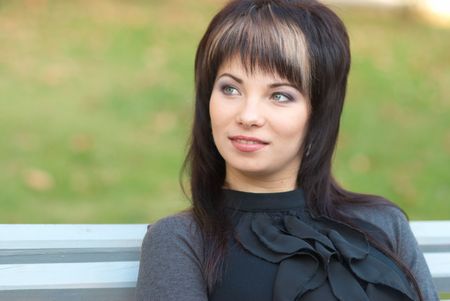 Portrait of beautiful girl sitting on the benchの写真素材