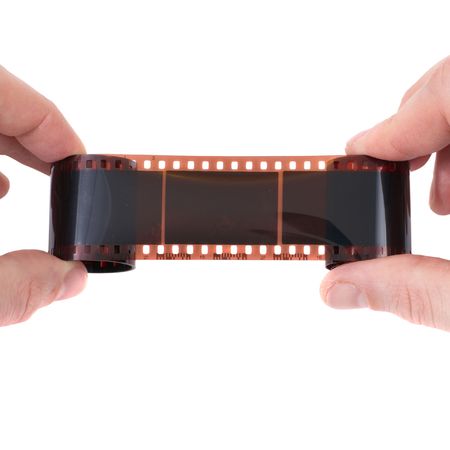 Old photographic film in the hands on white backgroundの写真素材