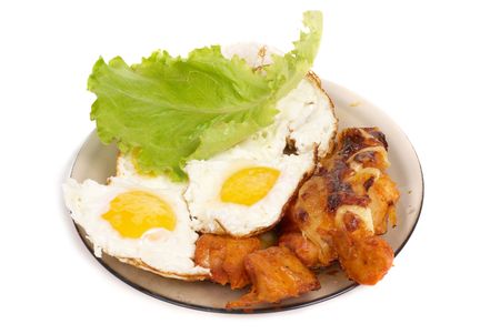 Fried eggs with meat on the dish isolated on whiteの写真素材