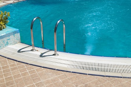 Swimming pool with stair and green relaxing waterの写真素材