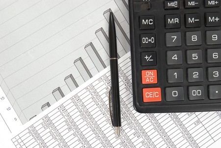 Pen and calculator on paper table with finance diagramの写真素材