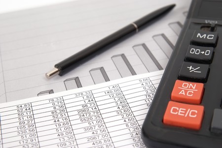 Pen and calculator on paper table with finance diagramの写真素材