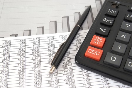 Pen and calculator on paper table with finance diagramの写真素材
