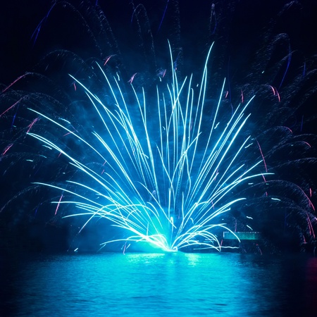 Blue fireworks on the black sky backgroundの写真素材