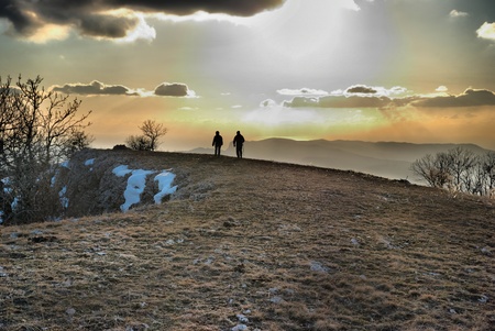 Couple on the hill against sunset. Landscape with clouds and sky.の写真素材