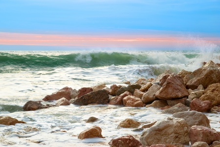 Sea landscape with waves on the beach against sunsetの写真素材