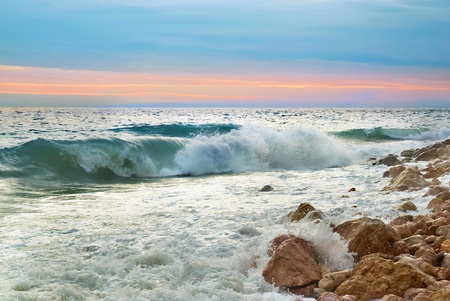 Sea landscape with waves on the beach against sunsetの写真素材