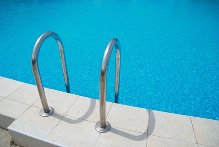 Swimming pool with stair and blue relaxing water