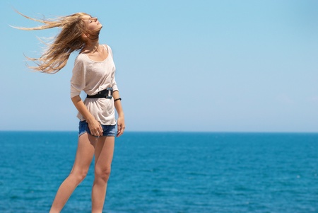 Beautiful blond girl outdoors against the sea の写真素材