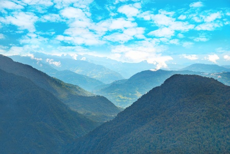 Green mountains with forest and blue cloudy skyの写真素材