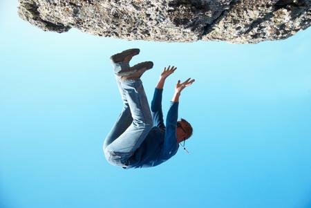 Falling down man from the rock with blue backgroundの写真素材