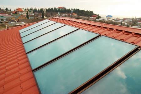 Solar water heating system  geliosystem  on the red house roof の写真素材