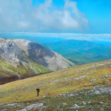 Mountain landscape with clouds and blue sky  Hiker climbing up the hill の写真素材