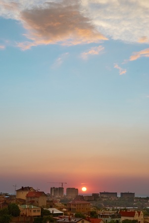 Sunset above the city with blue sky and cloudsの写真素材