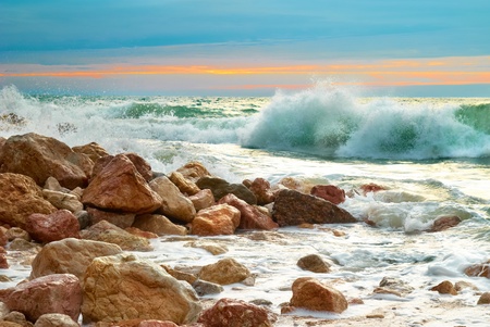 Sea landscape with waves on the beach against sunsetの写真素材