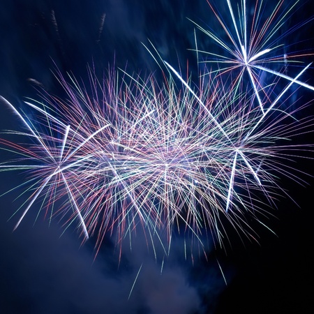 Blue colorful fireworks on the black sky background. Holiday celebration.の写真素材