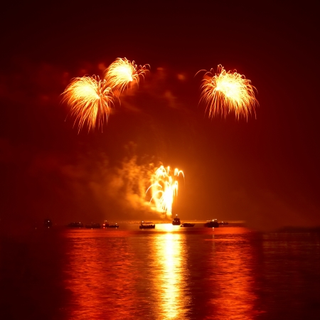 Red colorful holiday fireworks on the black sky background の写真素材