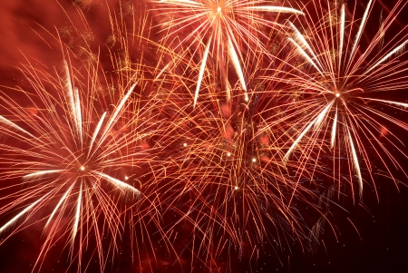 Red colorful holiday fireworks on the black sky background の写真素材