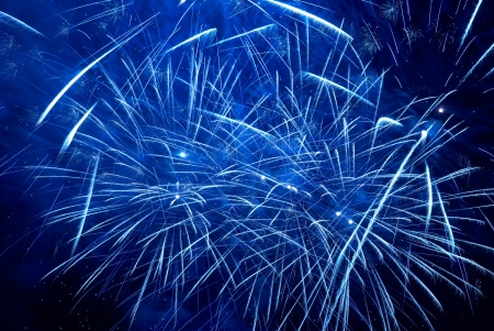 Blue colorful holiday fireworks on the black sky background の写真素材