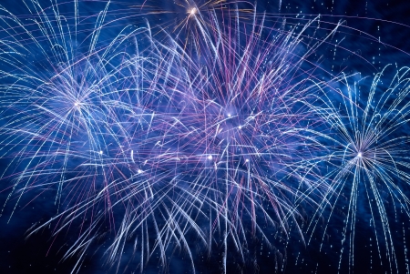 Blue colorful holiday fireworks on the black sky background の写真素材