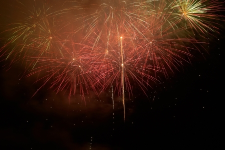 Red colorful holiday fireworks on the black sky background の写真素材